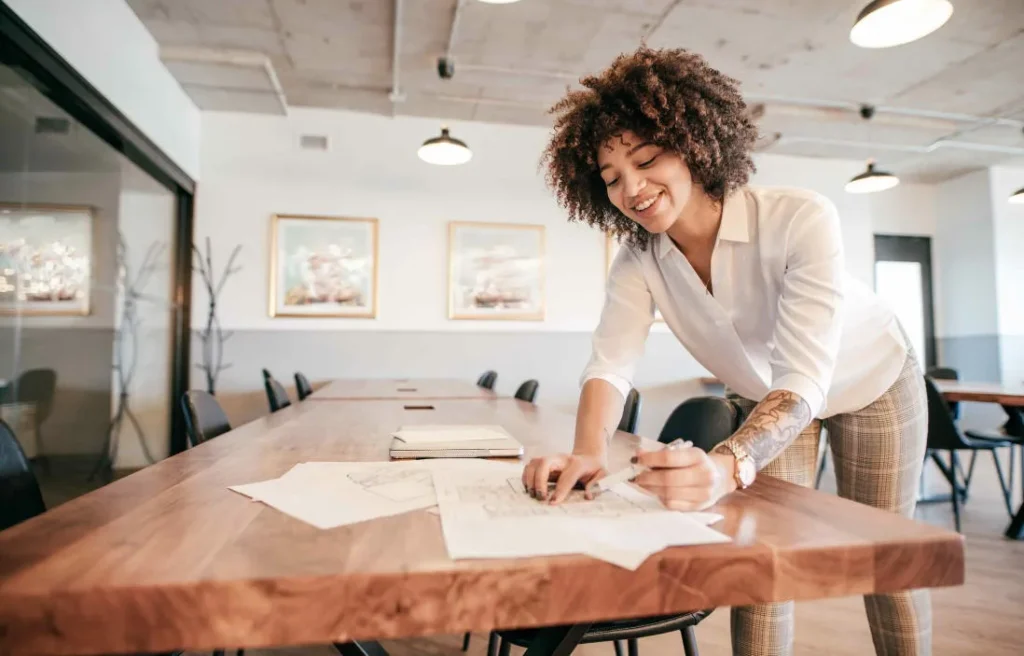 Woman reviewing architectural drawings in a modern Toronto office, highlighting the city’s higher education opportunities.