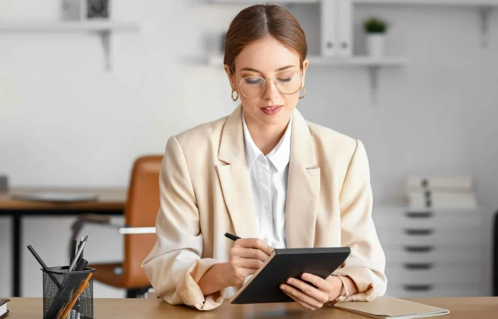 Professional woman reviewing documents on a tablet while preparing for a Job in Miami.