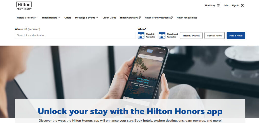 Person holding a smartphone with Hilton Honors app open, shown on Hilton website promoting app benefits.
