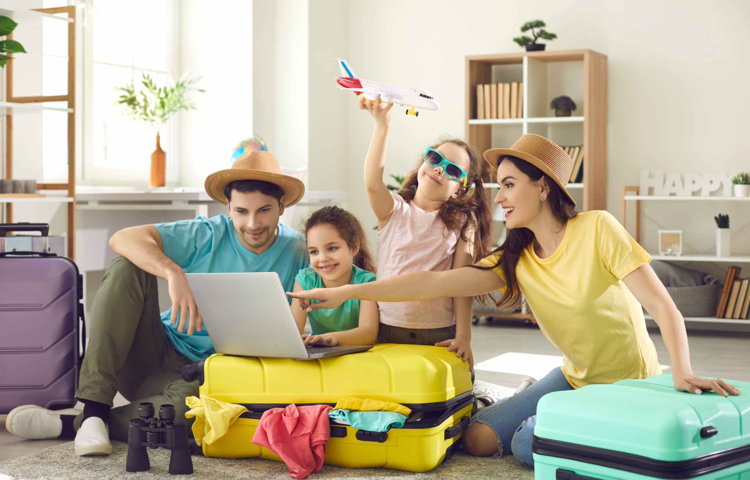 Happy Family Booking Flight and Hotels Online with Using Laptop