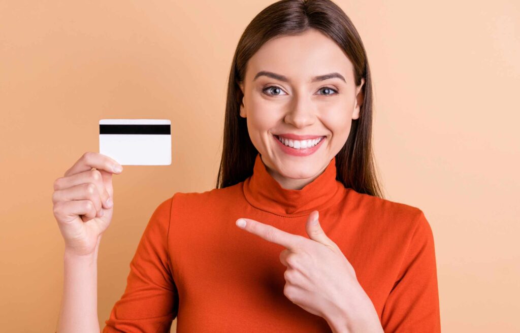 Happy Women Showing Credit Card - How to Get FREE Flights