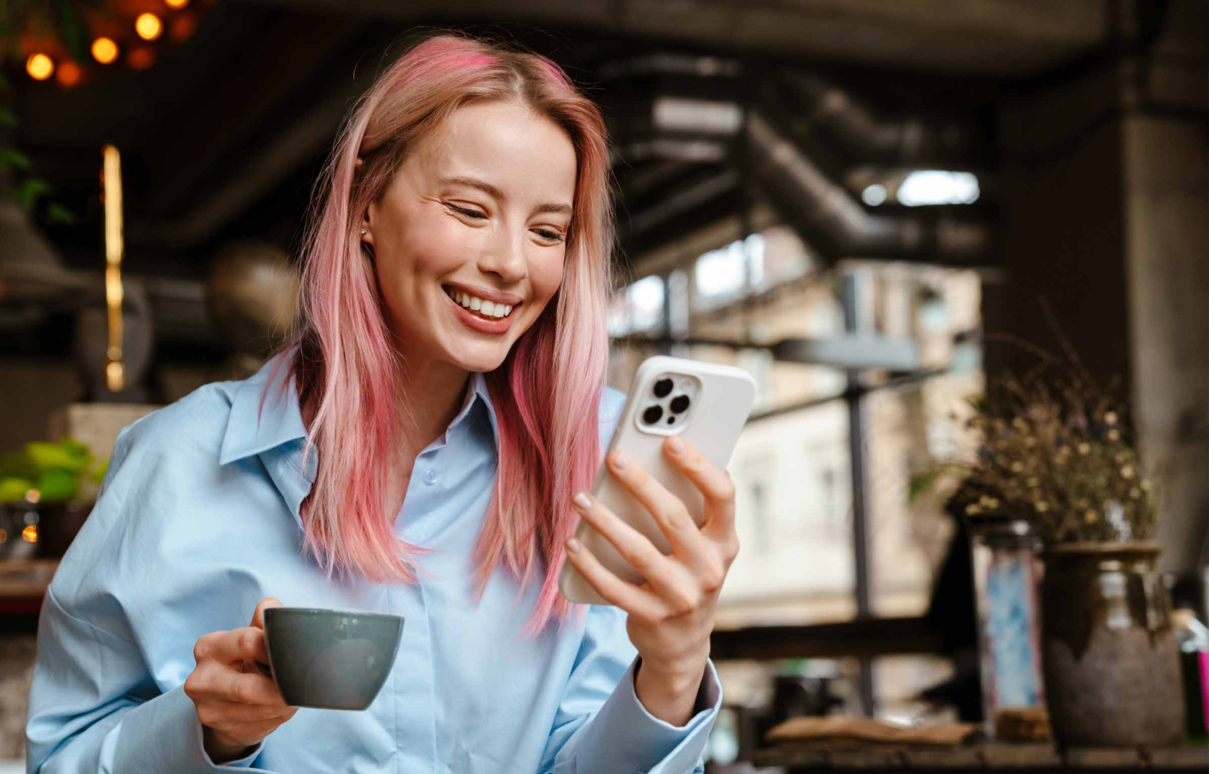 Happy Women Using Phone in Cafe