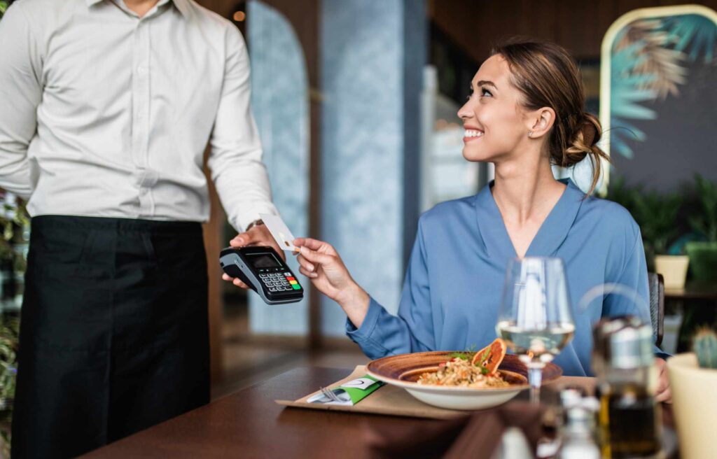 Women Paying Bill at Restaurant