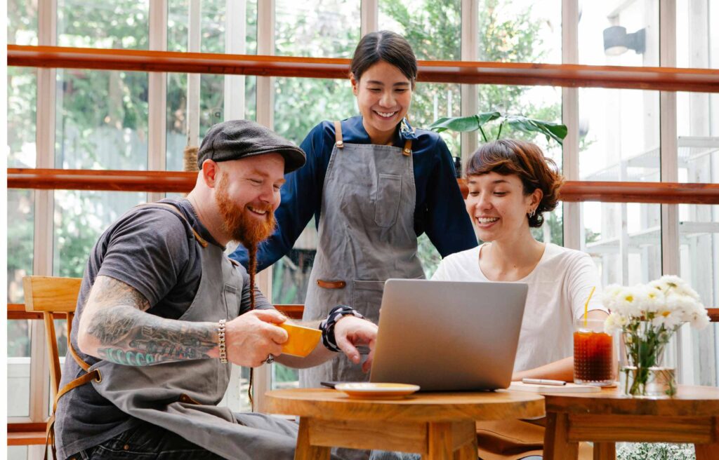 Colleagues working on laptop and finding secured business credit cards online