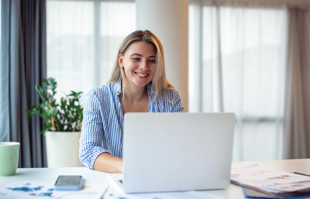 Beautiful woman freelancer noting information for planning project doing remote job via laptop computer. woman reading email on modern laptop device in Zoom Towns