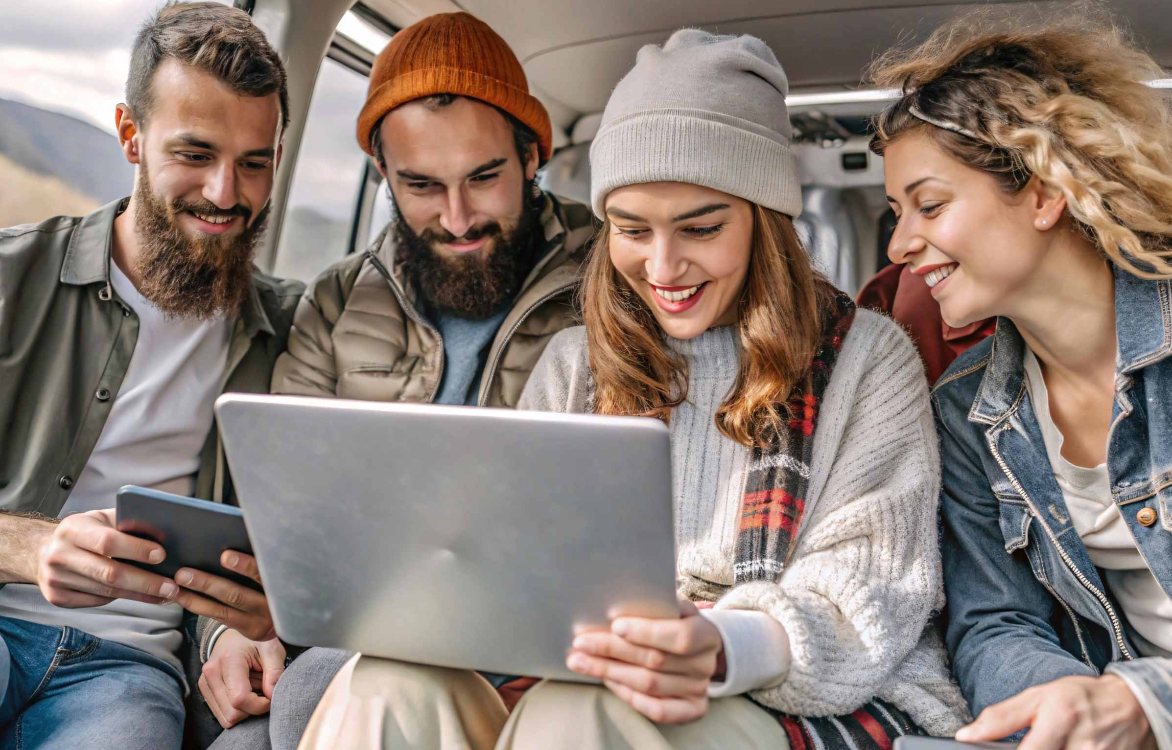 Friends Sharing Laptop Outdoors, Travel Planning or Working Remotely. A group young friends, two men and two women, are gathered outdoors, possibly on a travel adventure, sharing a laptop