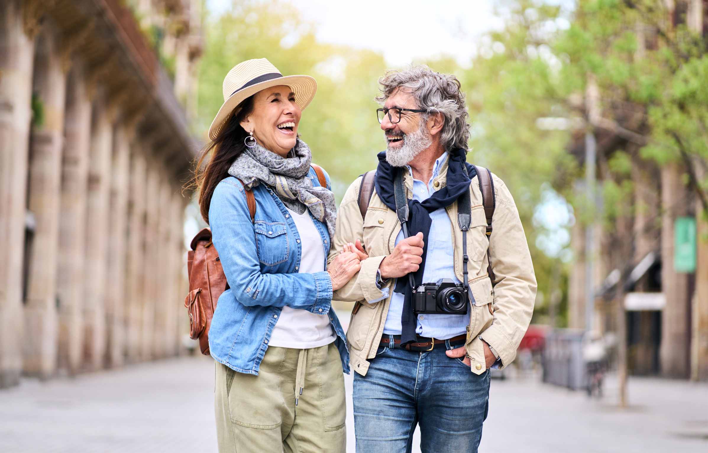 Happy older couple having fun walking outdoors in city. Retired people enjoying a sightseeing walk