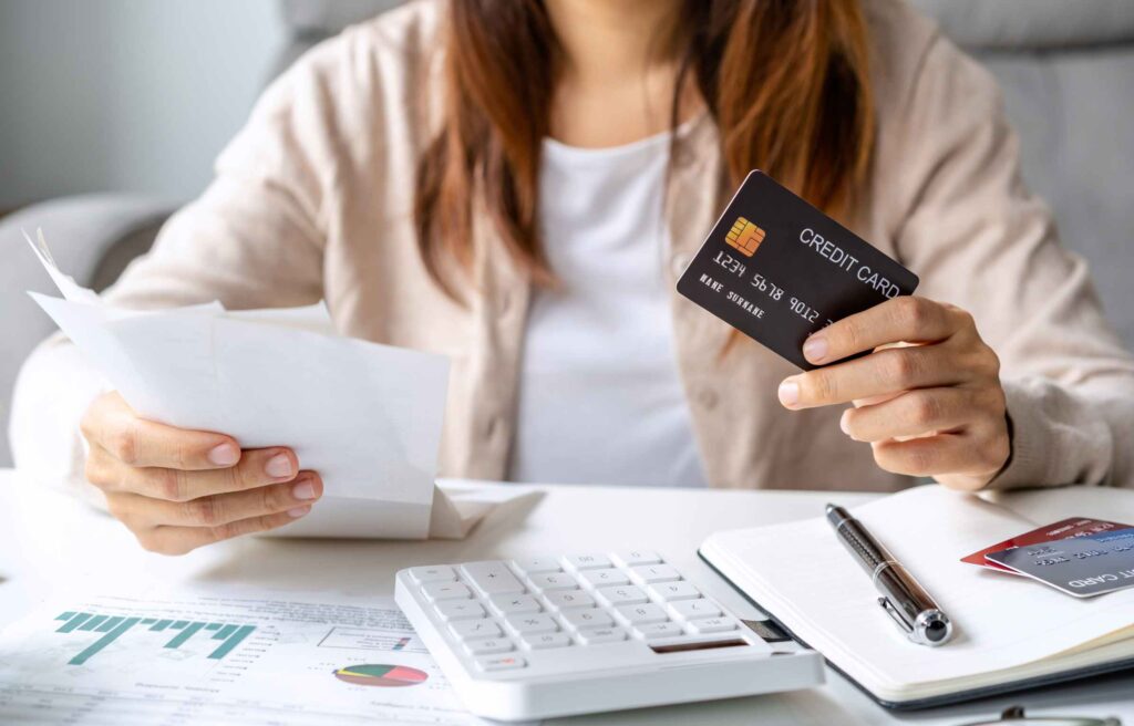 Young woman calculating monthly home expenses, taxes, bank account balance and credit card bills payment, Income is not enough for expenses