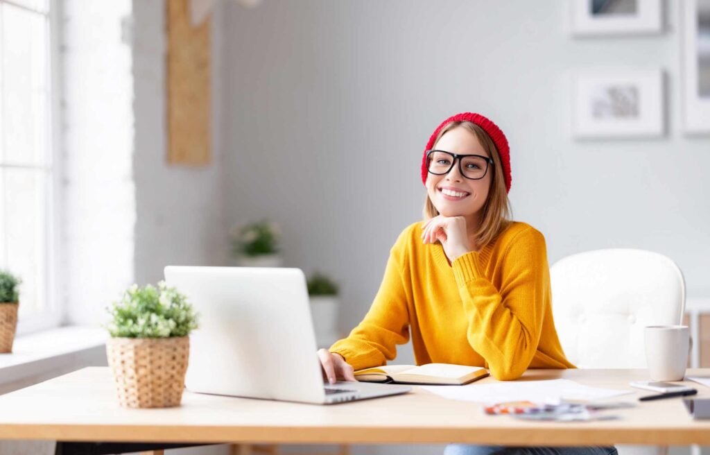 Cheerful freelancer using laptop during work
