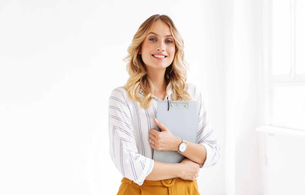 Image of attractive elegant businesswoman holding clipboard in office