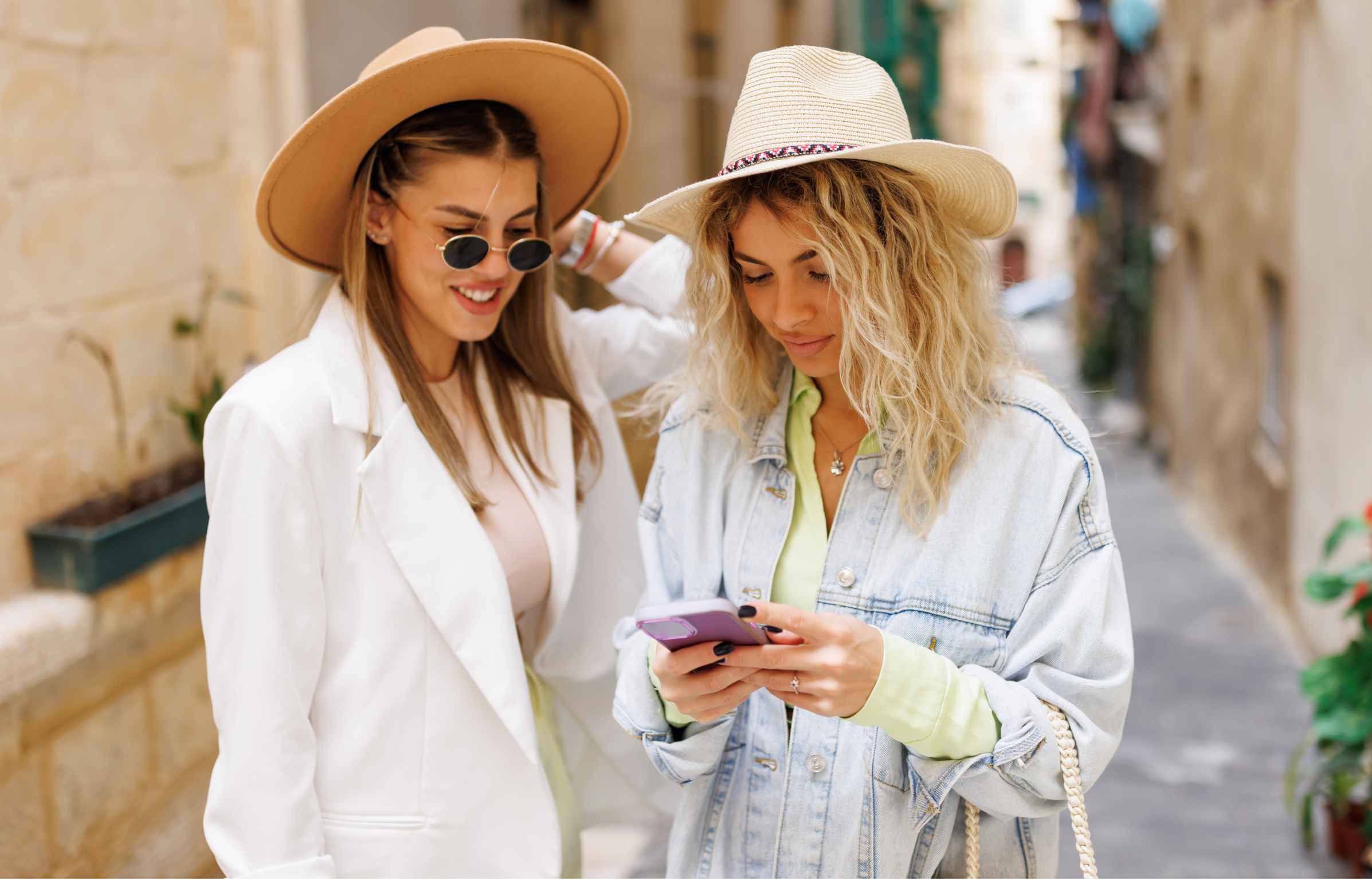 Young female tourists using phone to explore old Mediterranean town