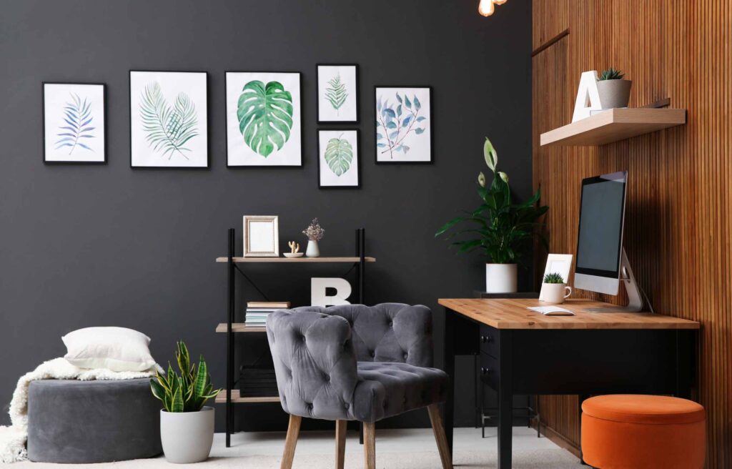 Comfortable workplace with computer near wooden wall in stylish room interior. Home office design