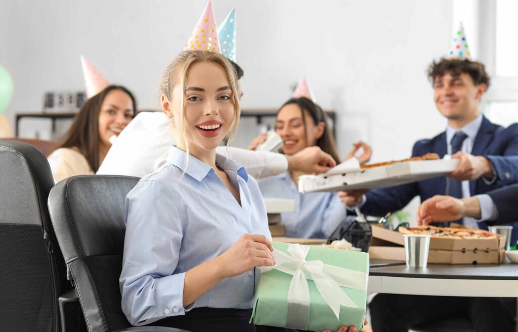 Young Woman with Gift at Birthday Party in Office