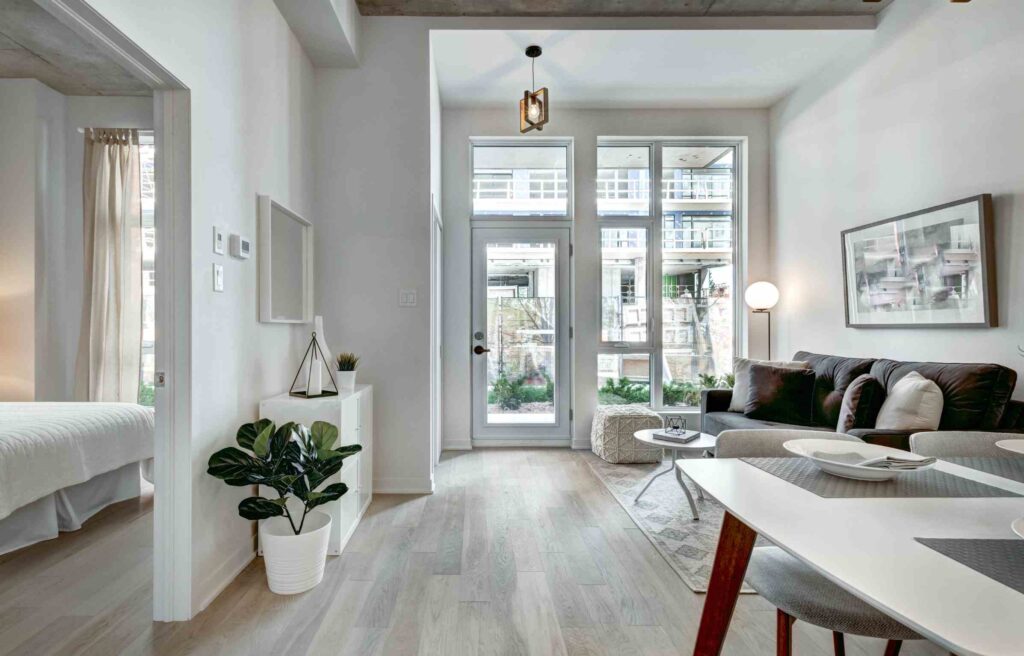 Bright modern condo with large windows and sleek decor, showing a typical space for how to buy a condo in boston.