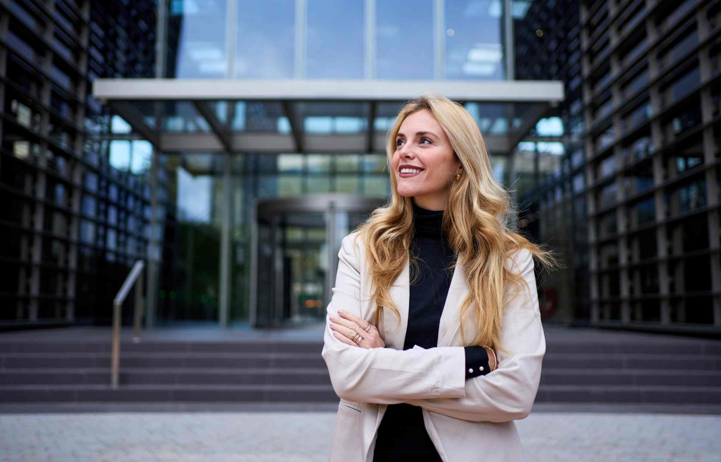 A confident businesswoman standing outside a modern office building.