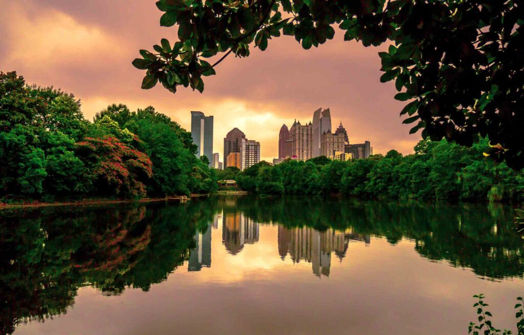 Atlanta skyline at sunset viewed from Piedmont Park lake, highlighting one of the best cities for new graduates in 2025.