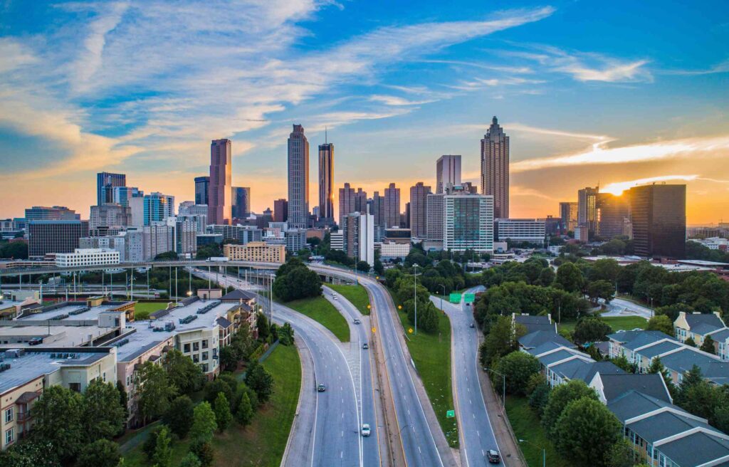 Aerial view of downtown Atlanta, Georgia with highways leading into the city skyline at sunset.