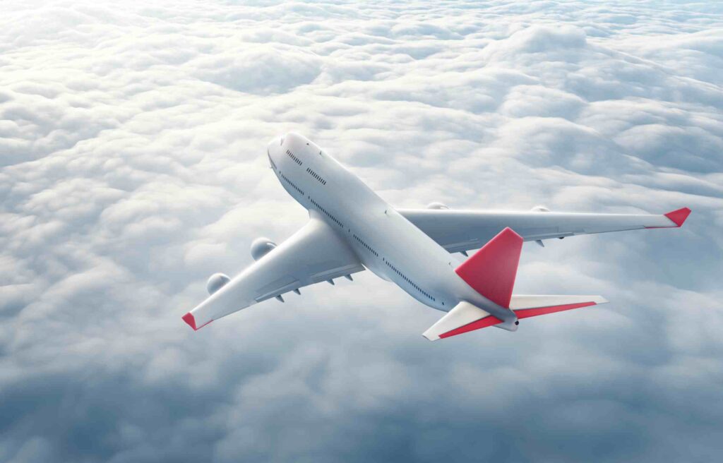 An aeroplane flying above the clouds, representing flight options available through the best travel reward programs.