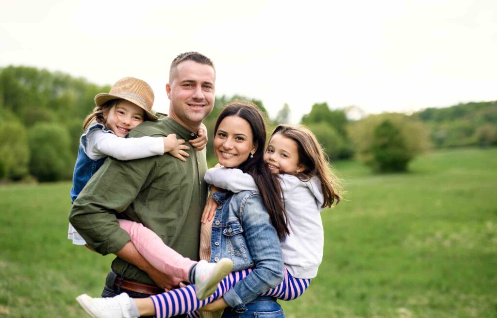 A gappy family with two children enjoying outdoor time together.