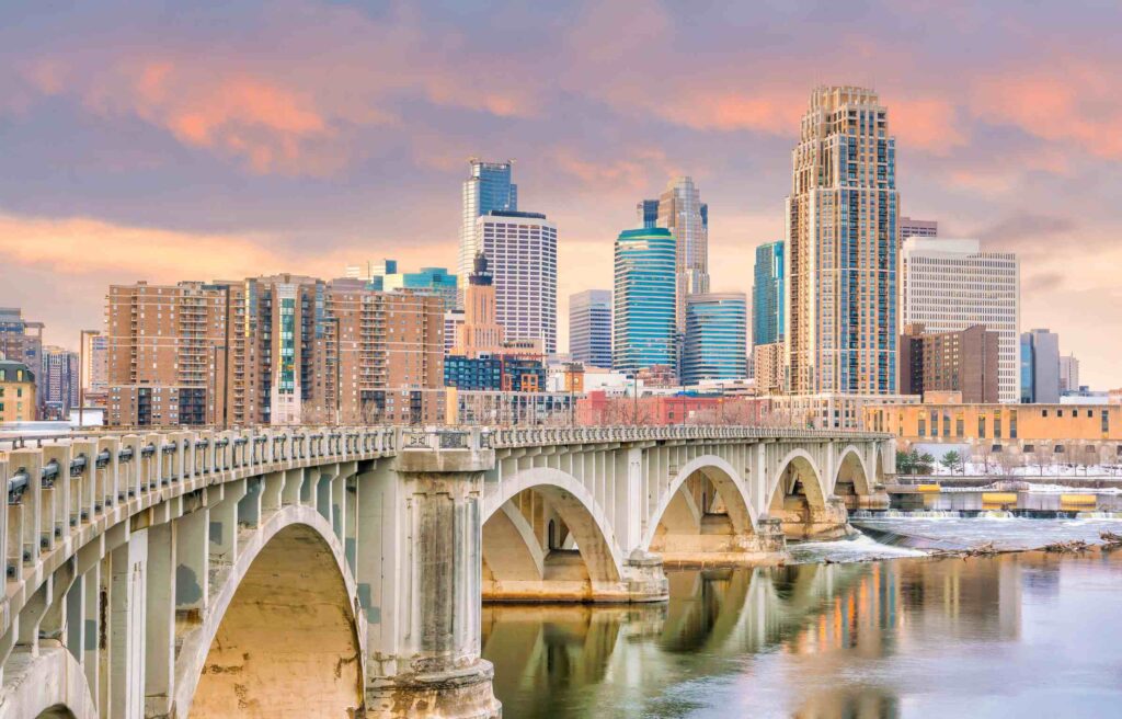 Minneapolis Minnesota skyline with bridge over the Mississippi River at sunset.