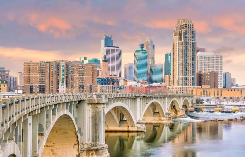 Minneapolis Minnesota skyline with bridge over the Mississippi River at sunset.
