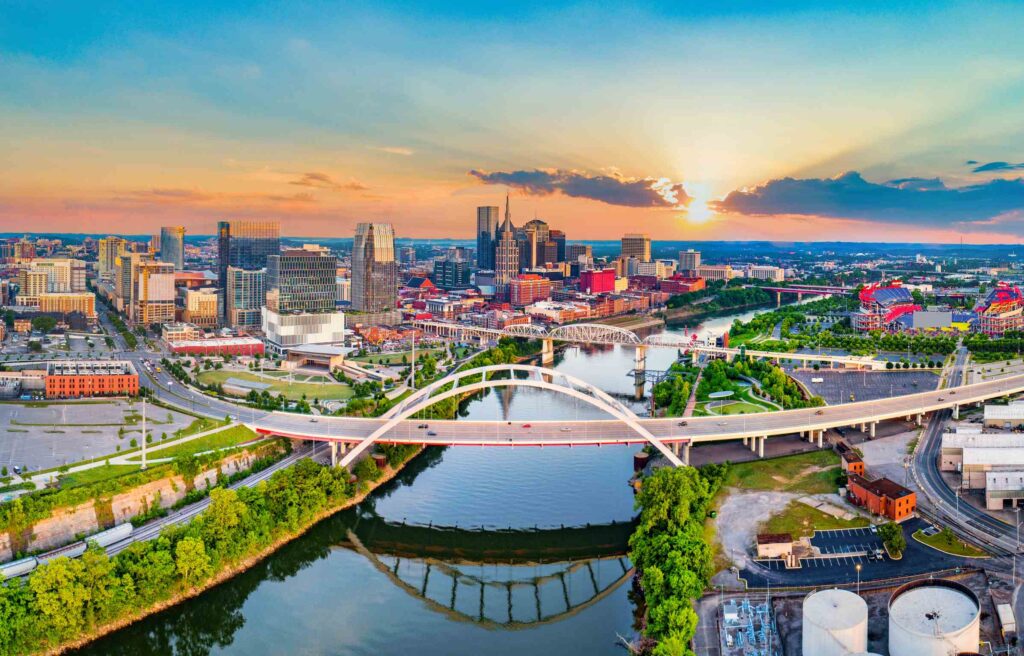 Aerial view of downtown Nashville, Tennessee, at sunset with bridges crossing the Cumberland River.