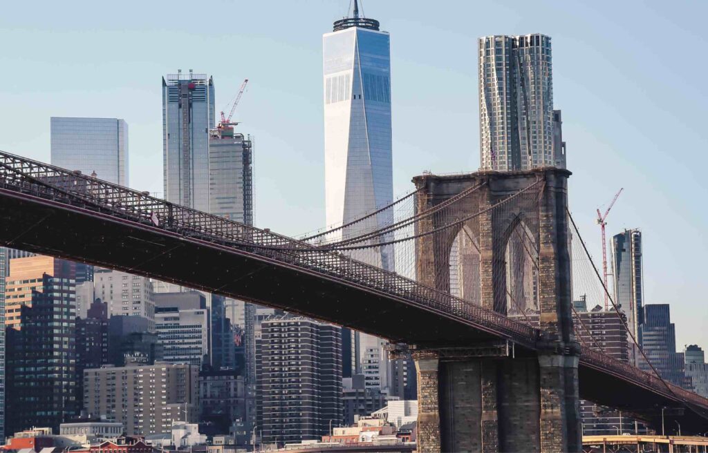 Brooklyn Bridge with the New York City skyline and One World Trade Center in the background.