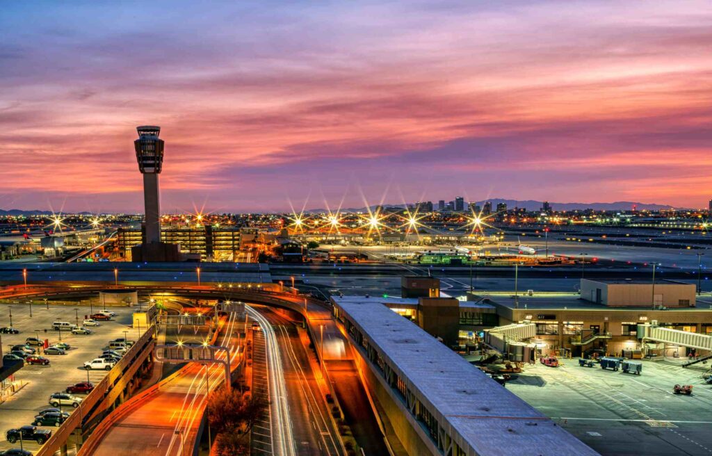 Phoenix Arizona city lights and airport control tower at sunset with vibrant sky colors.