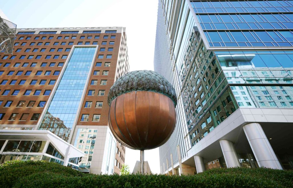 The giant copper acorn sculpture in downtown Raleigh, North Carolina, surrounded by modern office buildings.