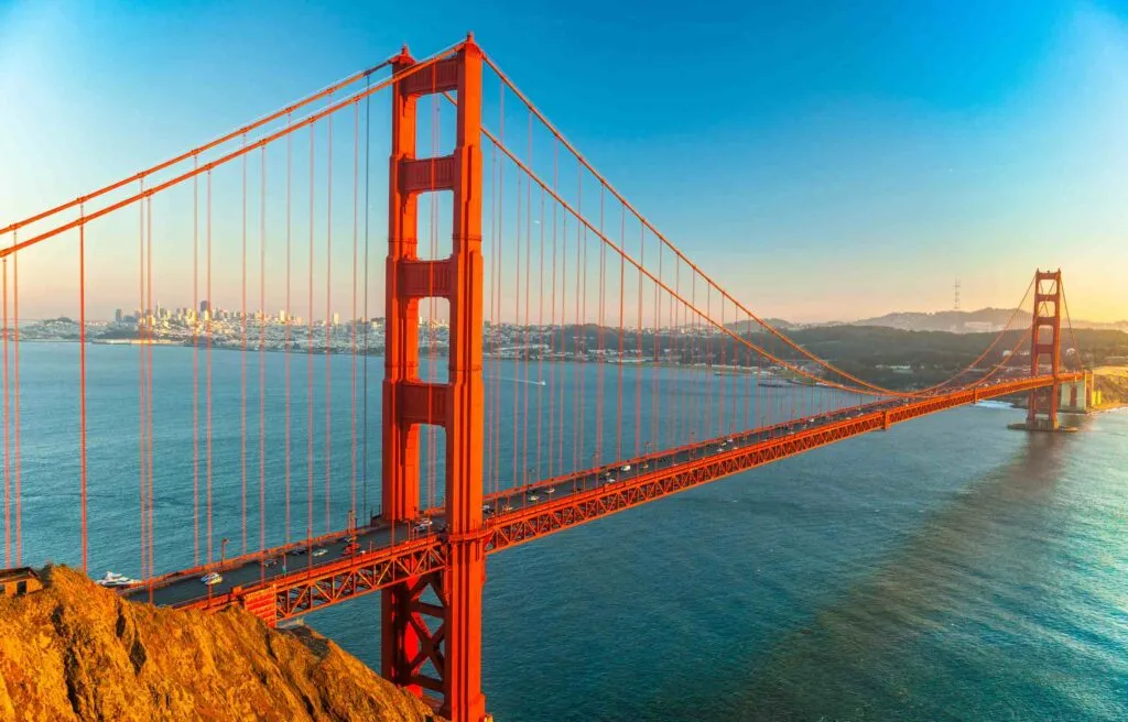 Golden Gate Bridge in San Francisco California with the city skyline in the background at sunset.
