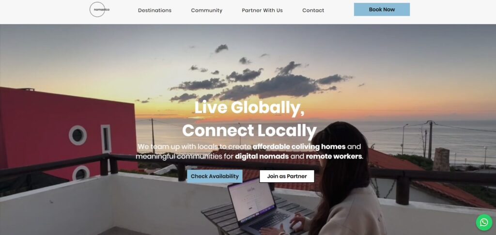 Nomadico.io homepage showing a woman working on a laptop from a balcony overlooking the ocean at sunset.