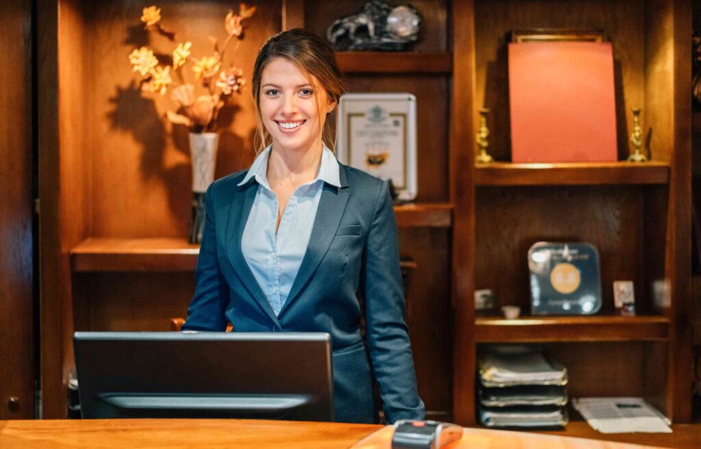 A hotel receptionist welcomes guests as part of the radisson rewards loyalty program experience.