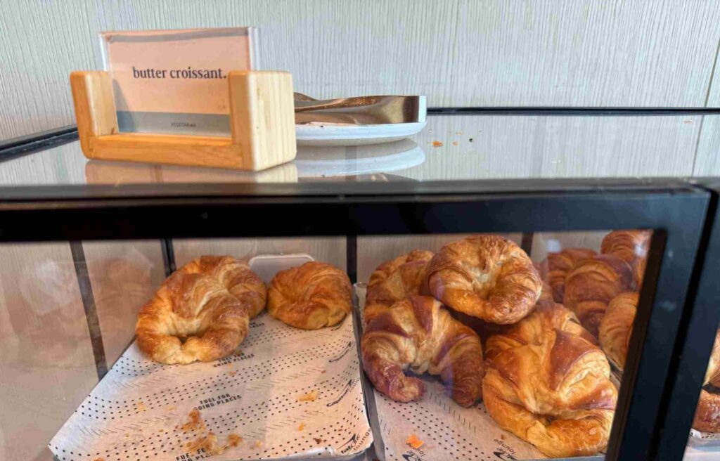 Fresh butter croissants displayed in a glass case at the Capital One Lounge.