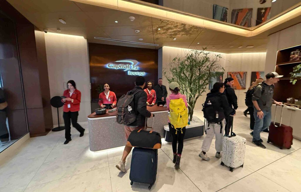 Lounge staff welcoming guests at the front desk with warm lighting and modern décor.