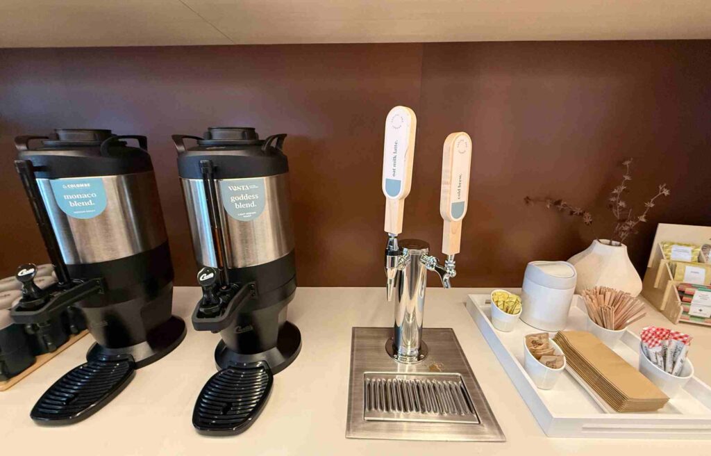 Coffee and cold brew station with labeled blends, condiments, and utensils.