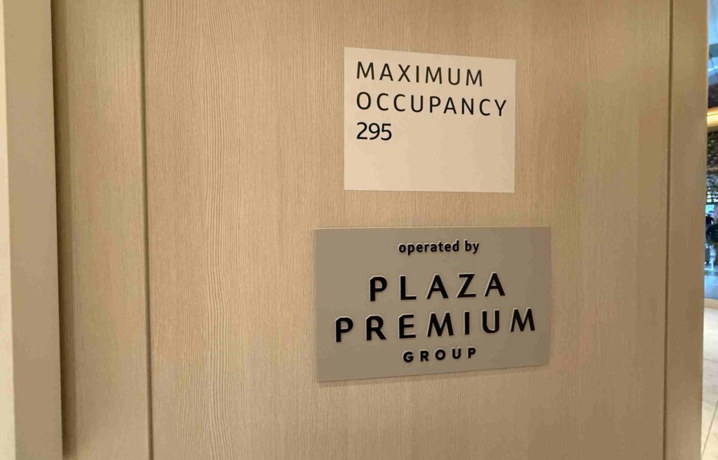 Sign showing Plaza Premium Group as the operator of the lounge with a maximum occupancy notice.