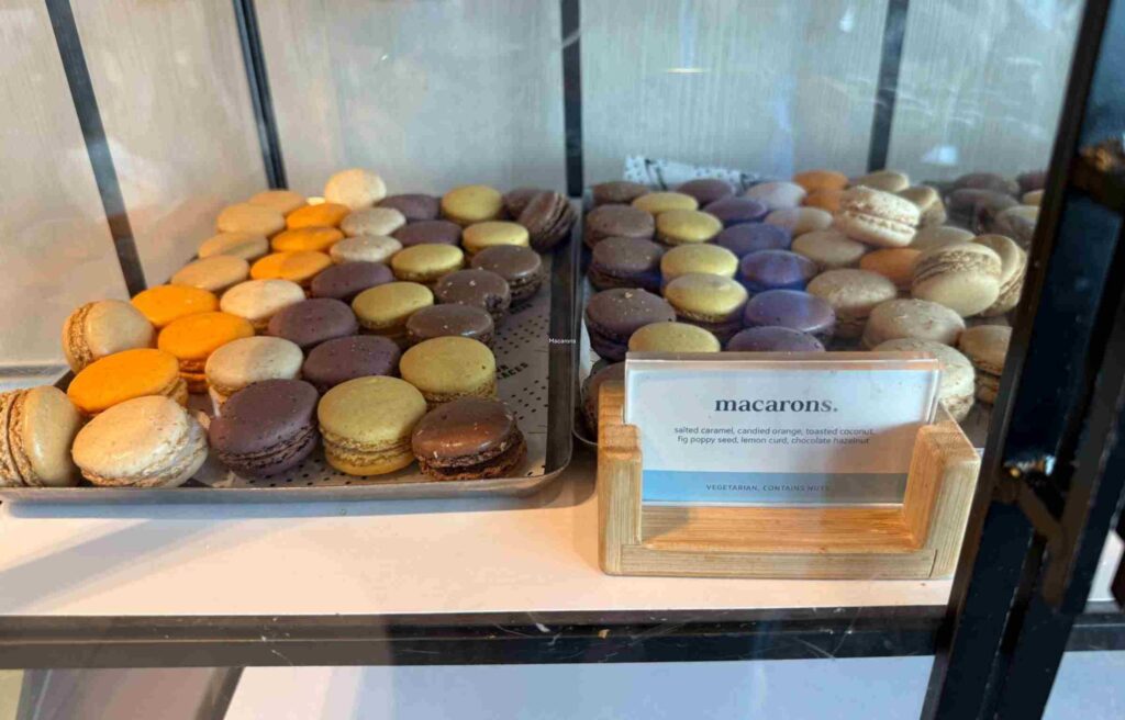 Assorted macarons in pastel colors including caramel, orange, and chocolate flavors.