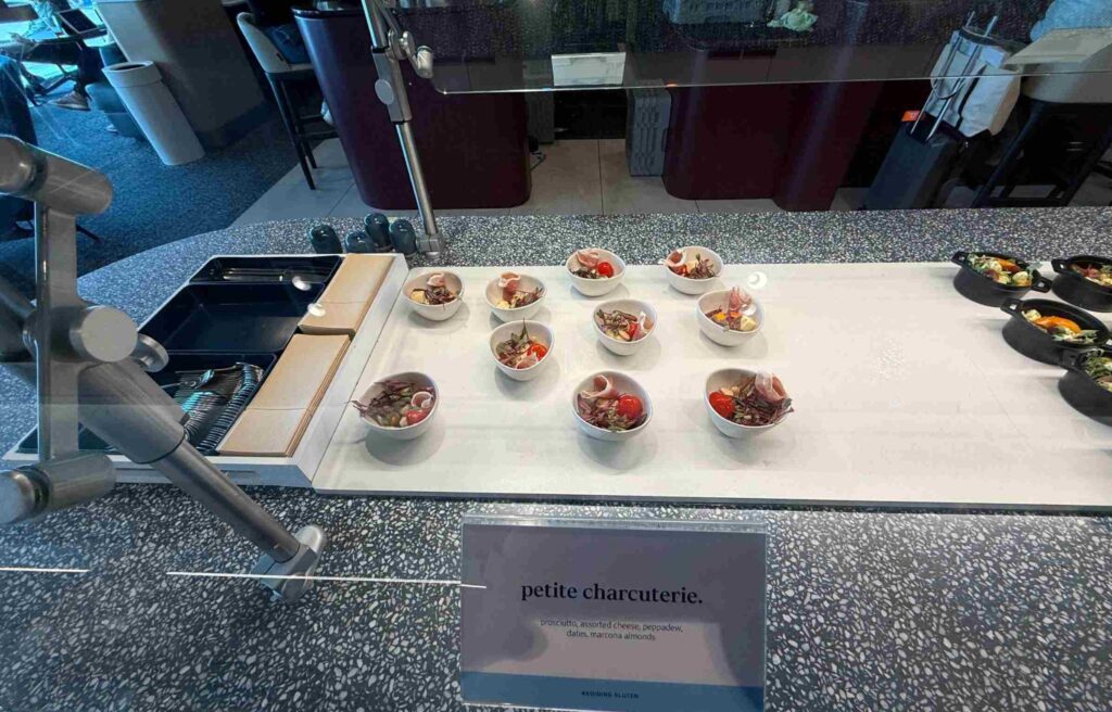 Small bowls of prosciutto, cheese, and dates arranged neatly at the Capital One Lounge buffet.