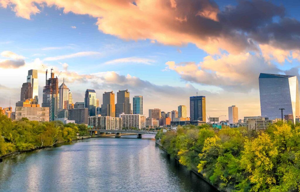 Philadelphia, Pennsylvania, skyline with modern skyscrapers and the Schuylkill River at sunset.