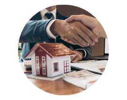 Business handshake beside a model house representing property investment.