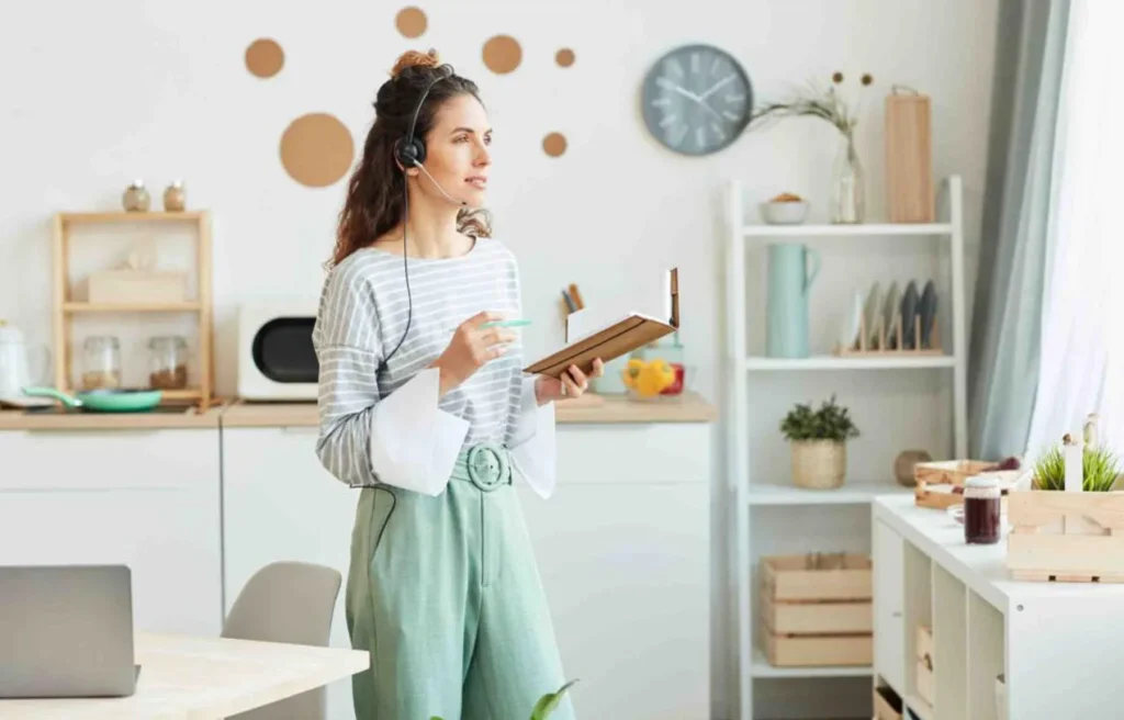 Woman working remotely in Scotland with a headset and notebook, representing flexible work life after moving to scotland from the usa.