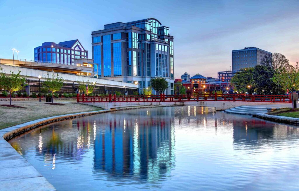 Modern buildings reflecting on the calm waters of downtown Florence in The Shoals, Alabama, during a peaceful evening.