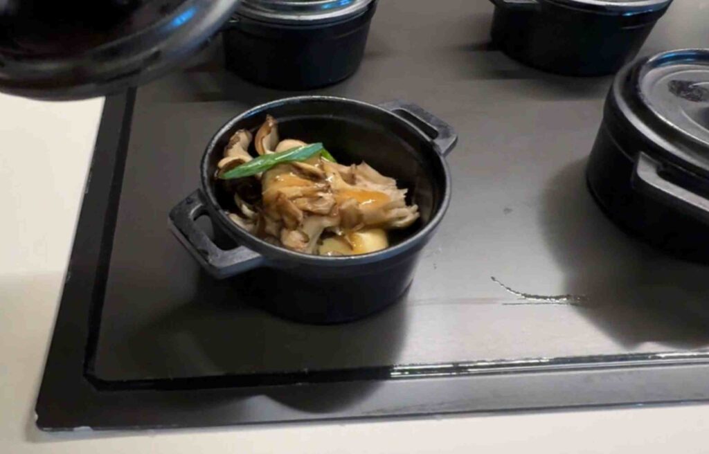 Black mini pots featuring mushroom steak served over creamy parsnip purée.
