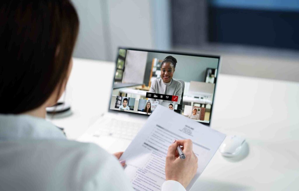 A candidate in an online job interview on a laptop, illustrating relocation vs remote hire cost analysis.