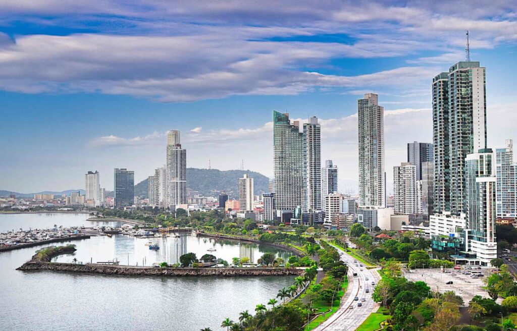 Skyline view of Panama City with modern high rise buildings, waterfront roads, and lush green parks.