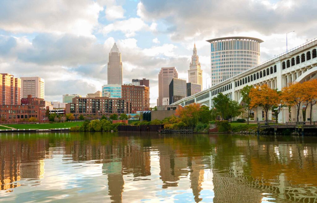 Cleveland skyline reflected in the Cuyahoga River near the city waterfront.