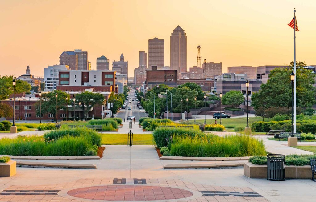 Des Moines skyline viewed from a landscaped park during sunset, a city known for offering many homes under $250k.