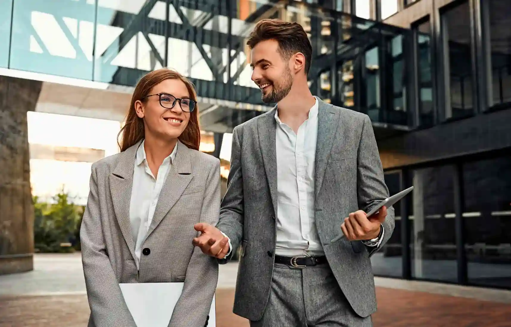 two employees walking near office discussing corporate relocation