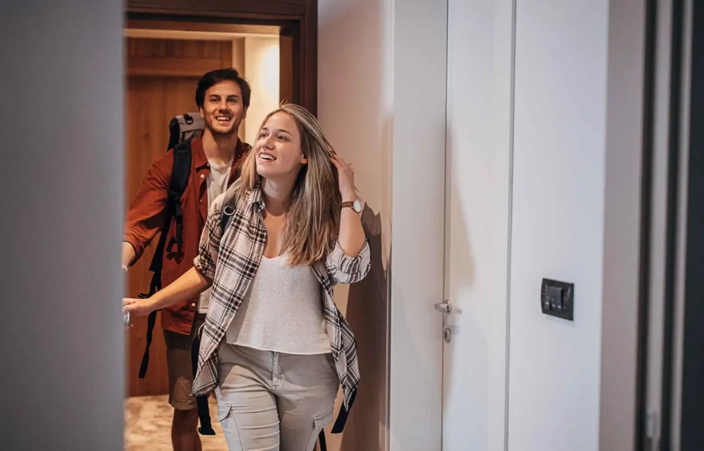 Couple settling into a hotel room, highlighting how to earn hilton honors points.