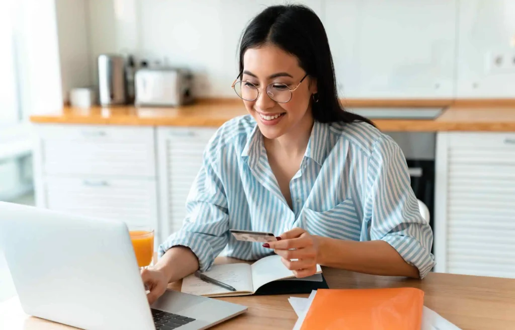 Woman managing rent payments online with new bilt card 2.0 at home.